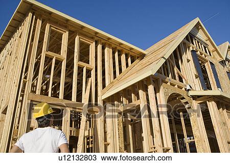 Construction worker observing unfinished house View Large Photo Image Stock Image - Construction worker observing unfinished house. Fotosearch