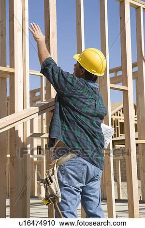 Construction Worker standing in front of house construction and gesturing View Large Photo Image Stock Image - Construction Worker standing in front of house construction and gesturing. Fotosearch