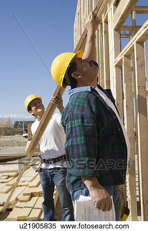 Construction workers holding planks View Large Photo Image Stock Photography - Construction workers holding planks. Fotosearch