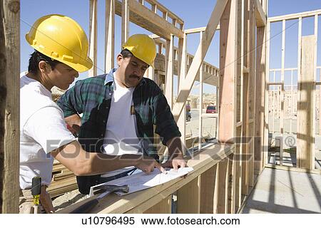 Construction workers reading blueprint on building site View Large Photo Image Stock Photography - Construction workers reading blueprint on building site. Fotosearch