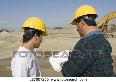 Stock Photography - Construction Workers reading blueprint. Fotosearch