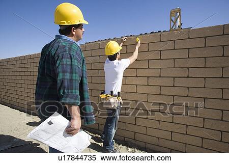 Construction workers standing in front of brick wall View Large Photo Image Stock Photography - Construction workers standing in front of brick wall. Fotosearch