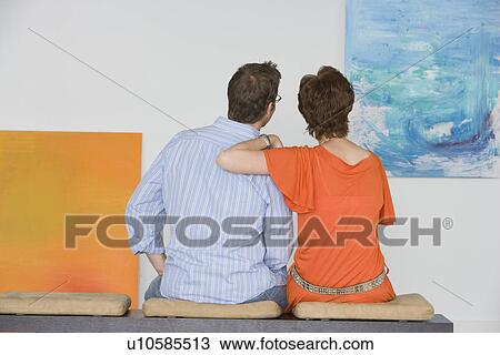 Couple contemplating paintings in gallery View Large Photo Image Stock Image - Couple contemplating paintings in gallery. Fotosearch