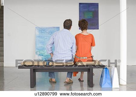 Couple contemplating paintings in gallery View Large Photo Image Stock Photo - Couple contemplating paintings in gallery. Fotosearch