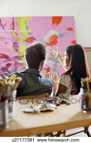 Couple discussing painting in artist's studio, back view View Large Photo Image Stock Image - Couple discussing painting in artist's studio, back view. Fotosearch