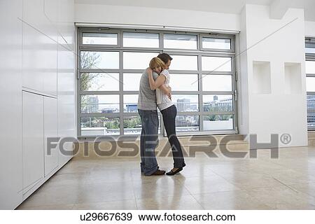 Couple embracing in empty apartment View Large Photo Image Stock Photo - Couple embracing in empty apartment. Fotosearch