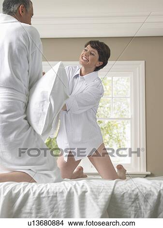 Couple having pillow fight on bed View Large Photo Image Picture - Couple having pillow fight on bed. Fotosearch