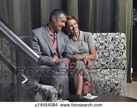 Picture - Couple having wine in hotel lobby. Fotosearch