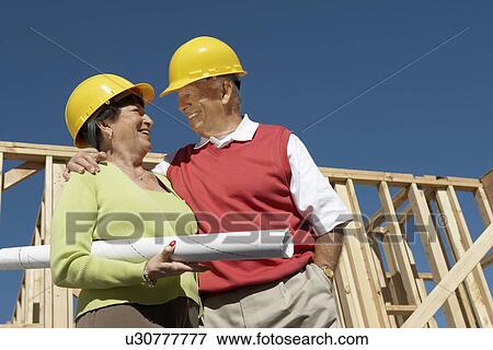 Couple in front of house being built, half-length View Large Photo Image Stock Photo - Couple in front of house being built, half-length. Fotosearch