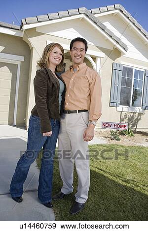 Stock Photo - Couple in front of new house, portrait. Fotosearch