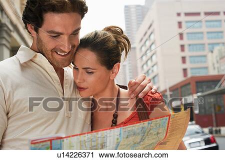 Stock Image - Couple looking at city map in street. Fotosearch