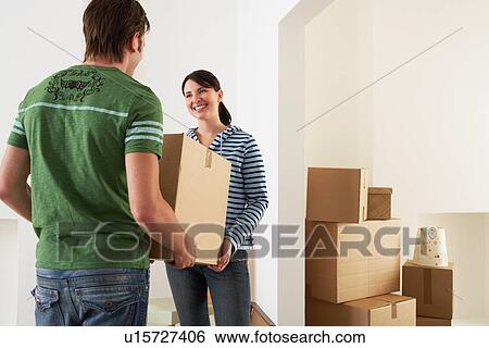 Couple Moving into New Home, carrying box View Large Photo Image Stock Photograph - Couple Moving into New Home, carrying box. Fotosearch