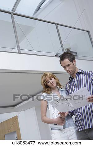 Couple observing plan in new home View Large Photo Image Stock Photo - Couple observing plan in new home. Fotosearch