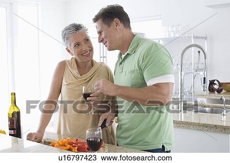 Couple preparing food in kitchen View Large Photo Image Stock Image - Couple preparing food in kitchen. Fotosearch