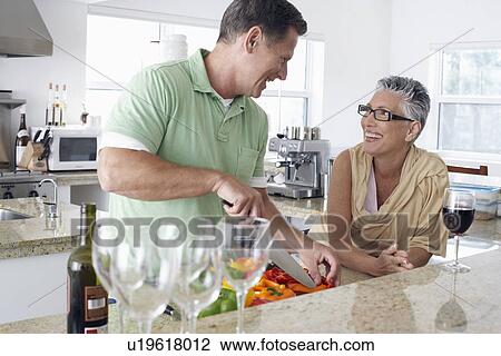 Stock Image - Couple preparing food in kitchen. Fotosearch