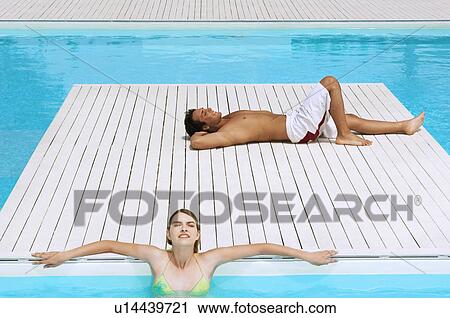 Couple Relaxing at Swimming Pool, high angle view View Large Photo Image Stock Image - Couple Relaxing at Swimming Pool, high angle view. Fotosearch
