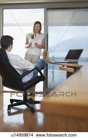 Couple relaxing in home office. View Large Photo Image Picture - Couple relaxing in home office.. Fotosearch