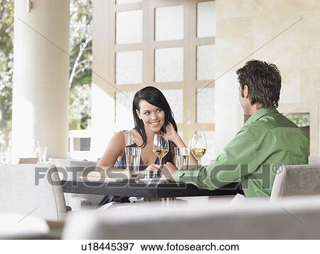 Stock Photo - Couple sharing wine at outdoor restaurant. Fotosearch