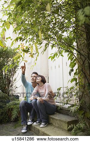 Couple sitting on steps looking up View Large Photo Image Stock Photograph - Couple sitting on steps looking up. Fotosearch
