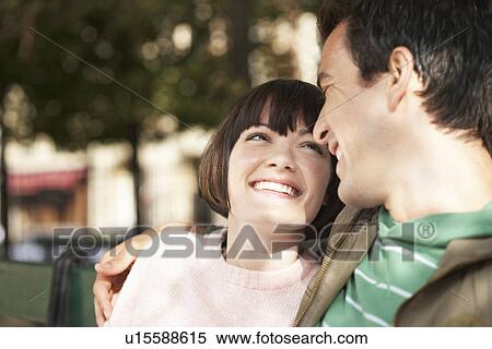 Couple smiling at each other on bench in park, head and shoulders View Large Photo Image Stock Photography - Couple smiling at each other on bench in park, head and shoulders. Fotosearch