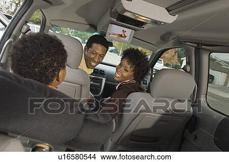 Couple smiling at young son in car View Large Photo Image Picture - Couple smiling at young son in car. Fotosearch