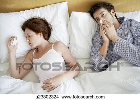 Couple with Colds Lying in Bed, high angle view View Large Photo Image Picture - Couple with Colds Lying in Bed, high angle view. Fotosearch