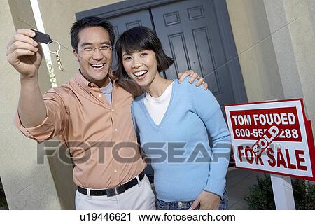 Stock Image - Couple with keys to new home. Fotosearch