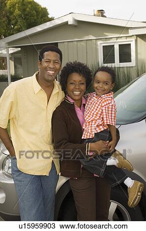 Couple with young boy standing by car in front of bungalow View Large Photo Image Stock Image - Couple with young boy standing by car in front of bungalow. Fotosearch