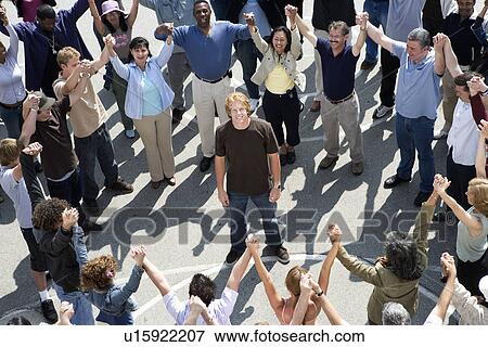 Crowd with arms raised surrounding young man View Large Photo Image Stock Photo - Crowd with arms raised surrounding young man. Fotosearch