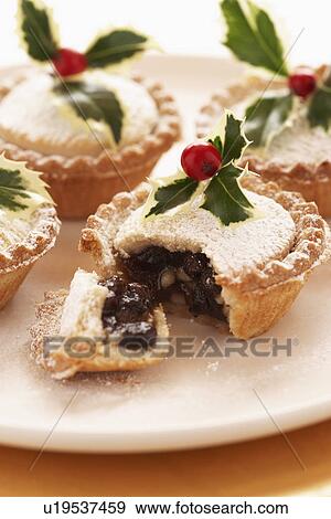 Stock Photo - Decorated mince pies on plate, close-up. Fotosearch