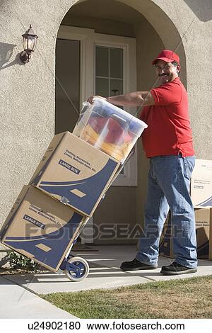 Delivery man holding cart with stack of containers View Large Photo Image Stock Image - Delivery man holding cart with stack of containers. Fotosearch