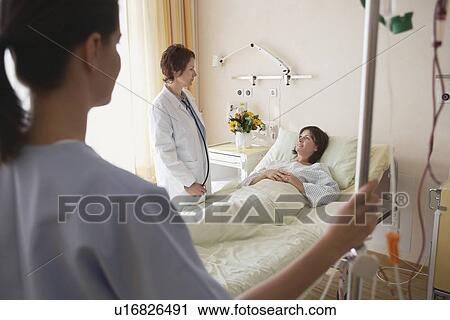 Doctor and Nurse With Patient in hospital room View Large Photo Image Stock Image - Doctor and Nurse With Patient in hospital room. Fotosearch
