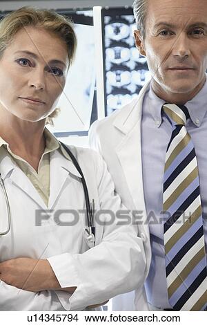 Picture - Doctors standing by brain scan images, portrait. Fotosearch