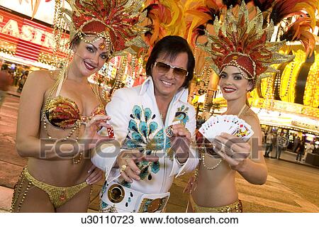 Stock Image - Elvis impersonator and female dancers having fun. Fotosearch