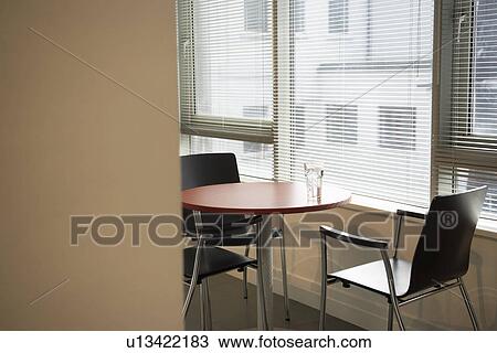 Stock Image - Empty office with water glass on table. Fotosearch