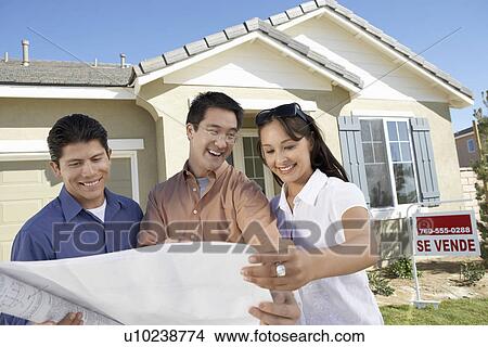 Family looking at plans in front of new home View Large Photo Image Picture - Family looking at plans in front of new home. Fotosearch