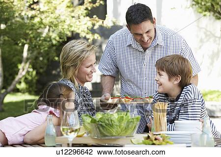 Family of four having lunch outdoors, portrait View Large Photo Image Stock Image - Family of four having lunch outdoors, portrait. Fotosearch