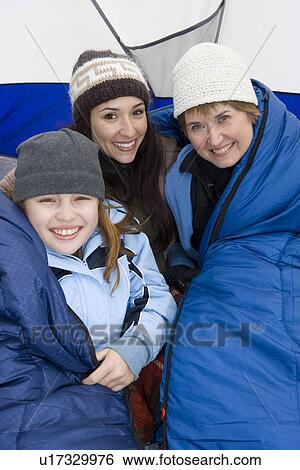 Stock Photograph - Family sitting in tent, smiling, portrait. Fotosearch