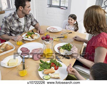 Stock Photograph - Family with children (3-6) at dining room table. Fotosearch