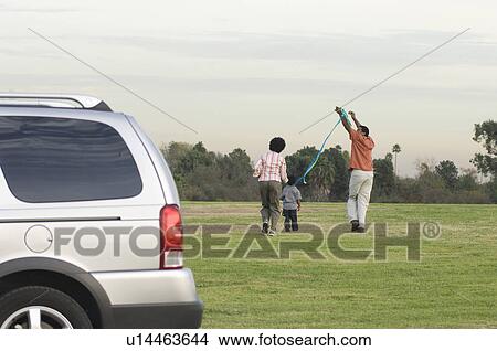 Picture - Family with one child (5-6) flying kite. Fotosearch