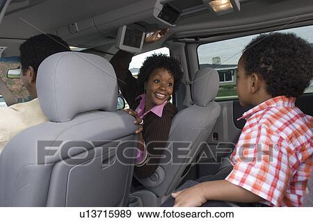 Stock Photo - Family with one child (5-6) in car. Fotosearch