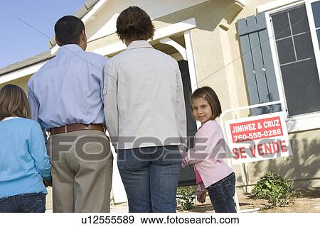 Family with two children (6-8) in front of new house, back view View Large Photo Image Stock Photo - Family with two children (6-8) in front of new house, back view. Fotosearch