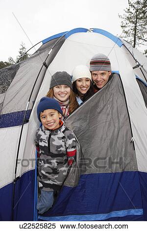 Stock Photography - Family with two children (7-12) in tent, (portrait). Fotosearch