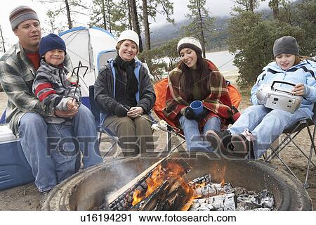 Family with two children (7-12) sitting around campfire, (portrait) View Large Photo Image Stock Image - Family with two children (7-12) sitting around campfire, (portrait). Fotosearch