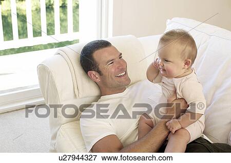 Father and baby on sofa View Large Photo Image Stock Photo - Father and baby on sofa. Fotosearch