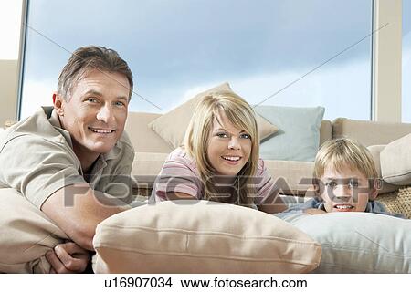 Picture - Father and Children reclining on pillows and cushions on Floor. Fotosearch
