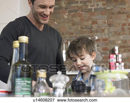 Stock Photo - Father and son (3-4) in kitchen. Fotosearch