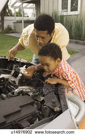 Father and young son inspecting car engine outside house View Large Photo Image Stock Image - Father and young son inspecting car engine outside house. Fotosearch