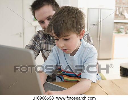 Stock Photo - Father Helping Son Use Laptop. Fotosearch