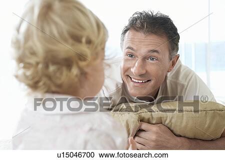 Stock Image - Father lying on bed Playing with Son, close-up. Fotosearch